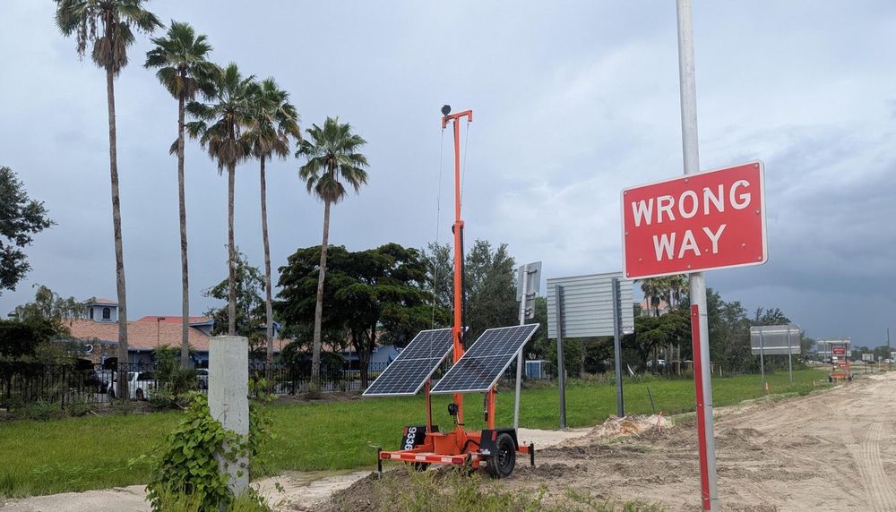 Portable trailer deployment beside a WRONG WAY sign on a divided roadway